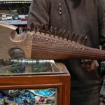 An Afghan amateur rubab player Gull Agha displays the rubab instrument at a shop in Herat, Afghanistan, on December 21, 2024. — AFP