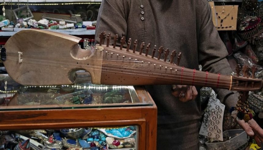 An Afghan amateur rubab player Gull Agha displays the rubab instrument at a shop in Herat, Afghanistan, on December 21, 2024. — AFP