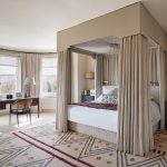 Designed by Bunny the bespoke fourposter bed in the main bedroom has curtains in a slubby linen by Sheila Coombes lined...