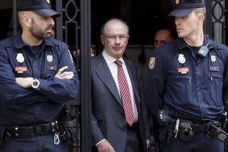 Former International Monetary Fund chief Rodrigo Rato (C) walks between police officers as he leaves his office in Madrid April 17, 2015. — Reuters