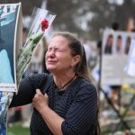 RE'IM, ISRAEL - OCTOBER 07: A woman breaks down at the memorial to Yulia Waxer Daunov as family members and friends of the lost and kidnapped gather at the site of the Nova Festival to mark the one year anniversary of the attacks by Hamas terrorists on October 07, 2024 in Re'im, Israel.