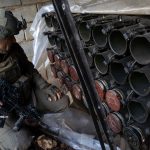 IDF soldier poses next to weapons cache