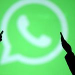 Silhouettes of mobile users are seen next to a screen projection of Whatsapp logo in this picture illustration. — Reuters