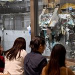 Customers watch a crane pick up rubbish for incineration at a combustible waste pit at the ‘Gomi Pit’ bar in Tokyo