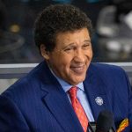 Greg Gumbel looks on