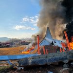 Firefighters carry out extinguishing operations on an aircraft which drove off runaway at Muan International Airport in Muan