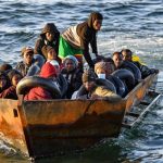 Migrants from sub-Saharan Africa sit in a makeshift boat off the coast of Tunisias city of Sfax on October 4, 2022. — AFP