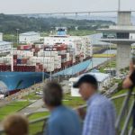 Tourists watch a Danish-flagged cargo ship passing through the Panama Canal. — AFP/File