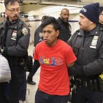 NYPD officers escort a suspect wanted for a homicide on the F Train in Coney Island