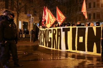 Police officers line up as far-right demonstrators hold a sign and flags during a protest after a car drove into a crowd at a Christmas market, in Magdeburg, Germany December 21, 2024. — Reuters