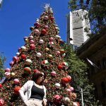 People take photos in front of a Christmas tree at the Martin Palace in Sydney on December 20, 2024. — AFP