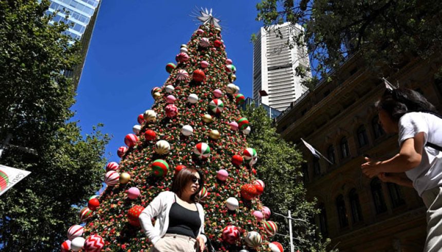 People take photos in front of a Christmas tree at the Martin Palace in Sydney on December 20, 2024. — AFP