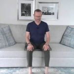 Man sitting on a couch practicing yoga for older adults