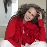 Andie MacDowell curly hair red outfit smile