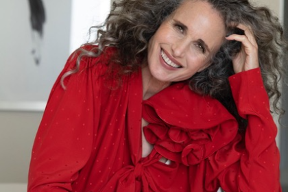 Andie MacDowell curly hair red outfit smile