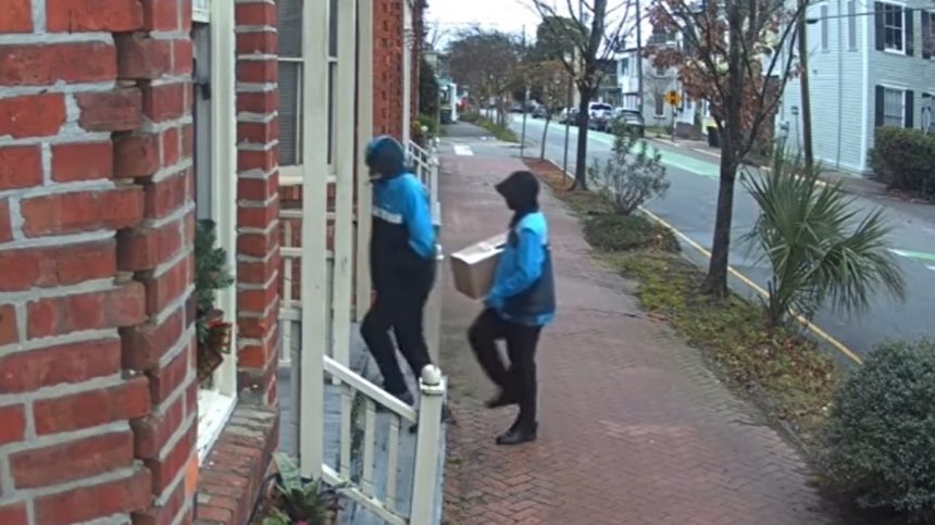 The two men disguised as Amazon workers approaching Hardison's door