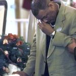 Oswald Clarke wipes tears from his eyes alongside his sister Karen's casket after her murder