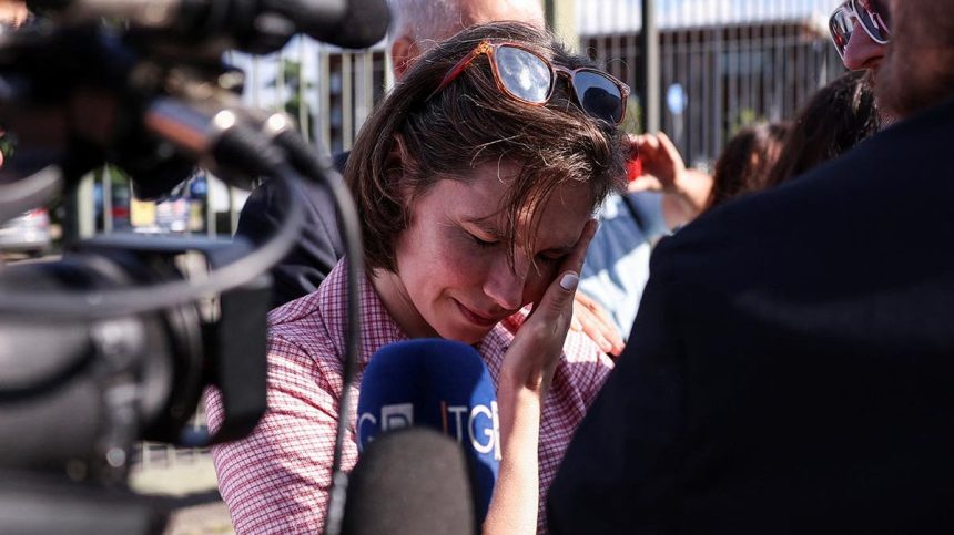 Amanda Knox in a checkered shirt is emotional as she arrives at court flanked by her two male lawyers