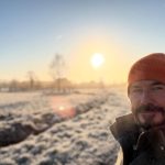 man standing in frosty garden