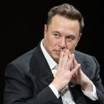 Elon Musk puts his hands together in thought