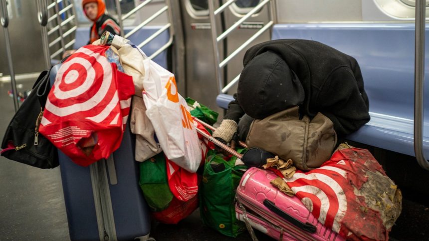 homeless man with their belongings in subway