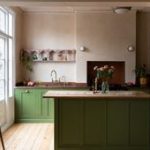 A kitchen with a wooden countertop and green island