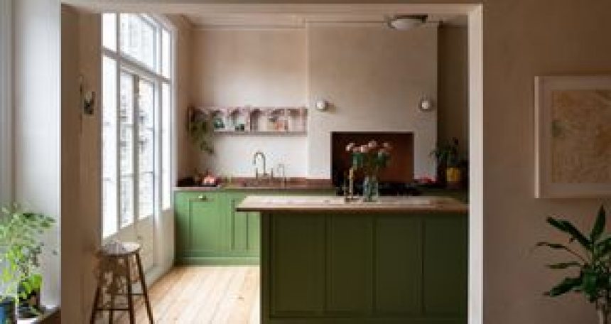 A kitchen with a wooden countertop and green island