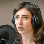 Italian journalist Cecilia Sala wears headphones and gestures as she speaks into a microphone.