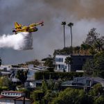 plane drops water on palisades fire