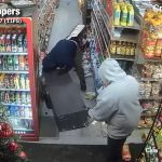 Two men drag an ATM out of a convenience store