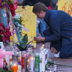 Nathan Williams, a University of New Orleans student, lights a candle at memorial on Bourbon Street