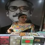 A sales person stands in front of a picture of Sheikh Mujibur Rahman. — Reuters/File