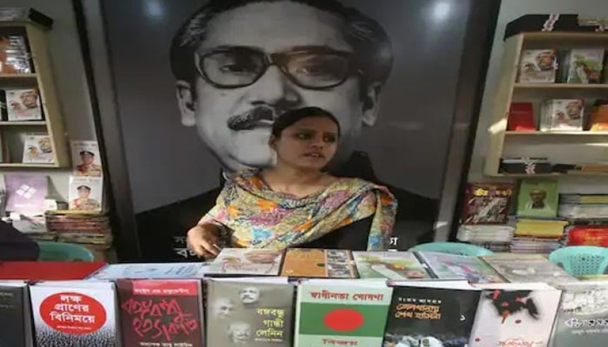 A sales person stands in front of a picture of Sheikh Mujibur Rahman. — Reuters/File