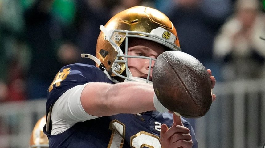 Riley Leonard points to his arm band