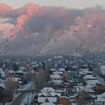 Steam rises from chimneys of the Gazprom Neft's oil refinery in Omsk