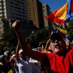 A supporter of Venezuela's opposition holds his arms up and shouts with fellow supporters ahead of President Nicolas Maduro's inauguration.