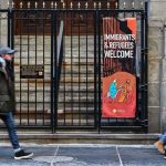 People walk past a church displaying an Immigrants & Refugees Welcome sign in New York on January 24, 2025. — AFP