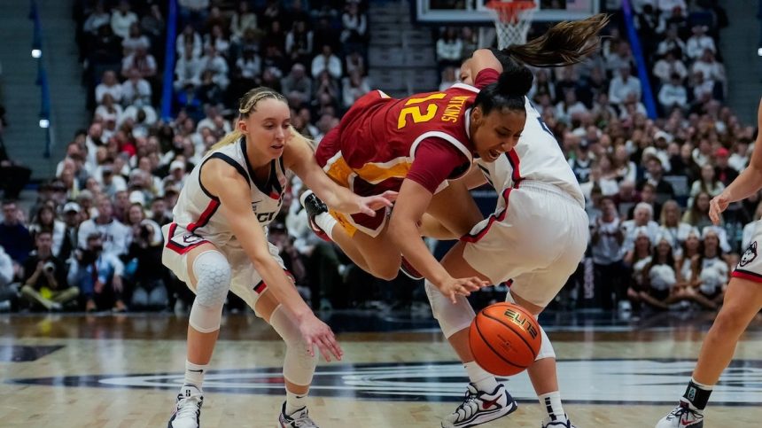 JuJu Watkins, center, is defended by Paige Bueckers and Kaitlyn Chen during the second half of an NCAA women's basketball game at the XL Center on Dec. 21, 2024 in Hartford, Connecticut.