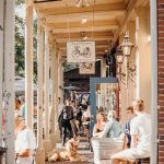 People dine outside on a brick-lined sidewalk