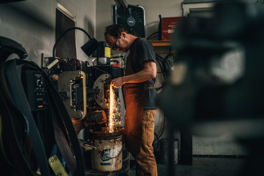 A man works in a black smithing studio