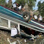 Volunteer firefighters work at the scene of an accident in which a bus fell down a ravine in Guatemala City on February 10, 2025. — AFP