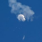 The suspected Chinese spy balloon drifts to the ocean after being shot down