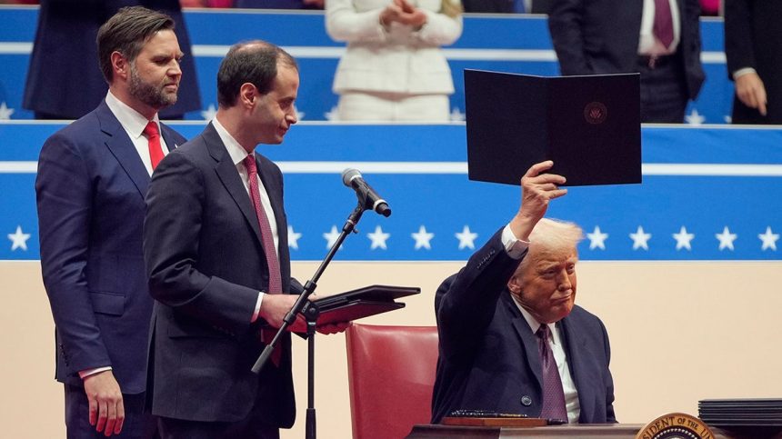 President Donald Trump signs executive orders on stage