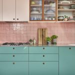 Bright light blue lower kitchen cabinets with bright pink kitchen cabinets above. Glass cabinets have also been integrated within the design, adding a seamless touch to the space. Baby pink zellige tiles have been used for the splashback.