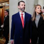 Donald Trump Jr. in a blue suit and red tie walks into the Rotunda with his daughter Kai Trump in a black jacket