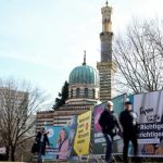 People walk past an election campaign poster of Friedrich Merz, Christian Democratic Union (CDU) party candidate for chancellor, the day before the parliamentary election, in Potsdam, Germany, February 22, 2025. — Reuters