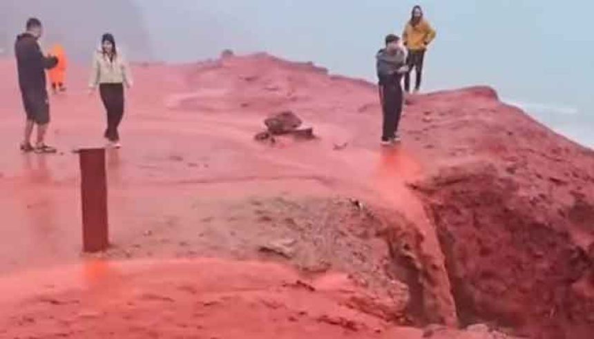 Visitors walk amid red floods caused by heavy rains at Red Beach in Hormuz island of Iran. — Screengrab/Facebook@Meteored