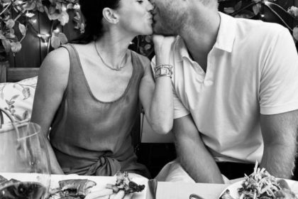 Meghan Markle and Prince Harry kissing at a meal