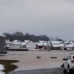 Cars park at the entrance of a flooded housing development after a rain storm in Kentucky, US on February 16, 2025. — AFP