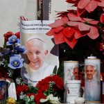 Decorated candles, flowers, and pictures of Pope Francis sit next to the statue of the late Pope John Paul II outside Gemelli Hospital, where Pope Francis is admitted for treatment, in Rome, Italy, on February 22, 2025. — Reuters